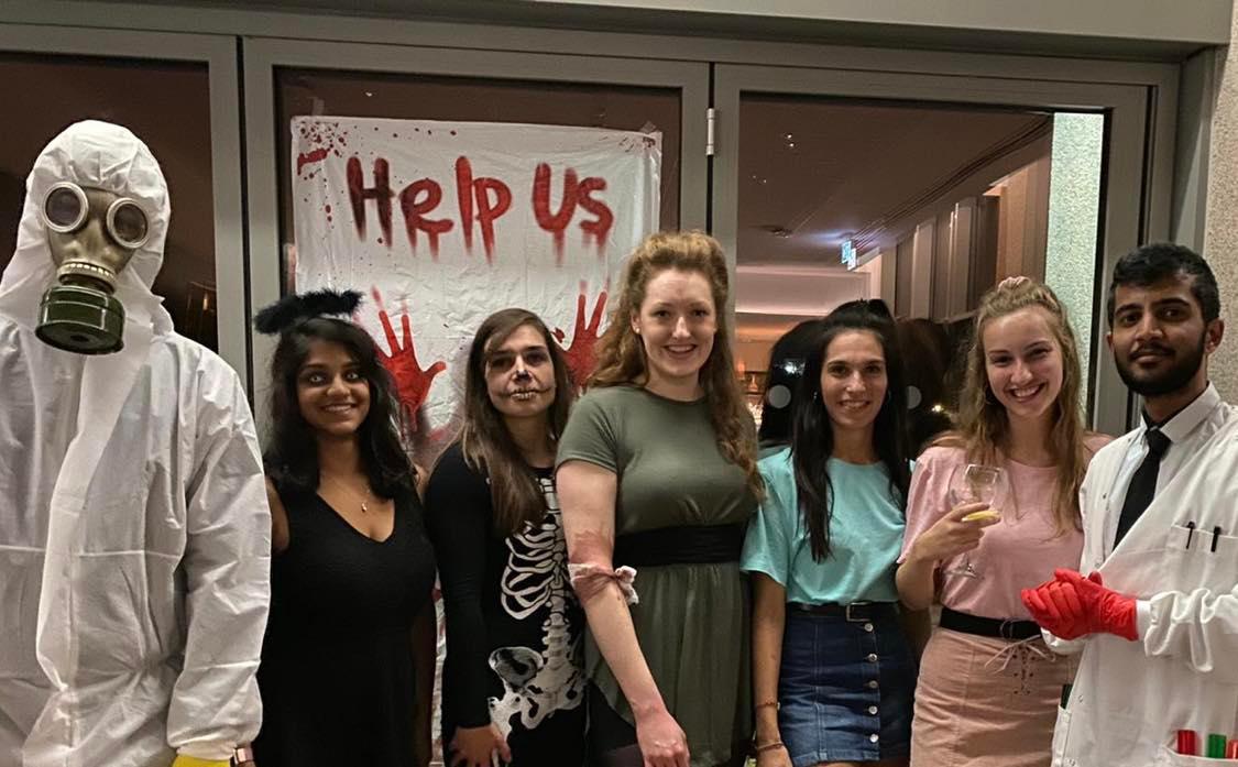 Students attending a Halloween party dressed as a zombie, skeleton and mad scientist