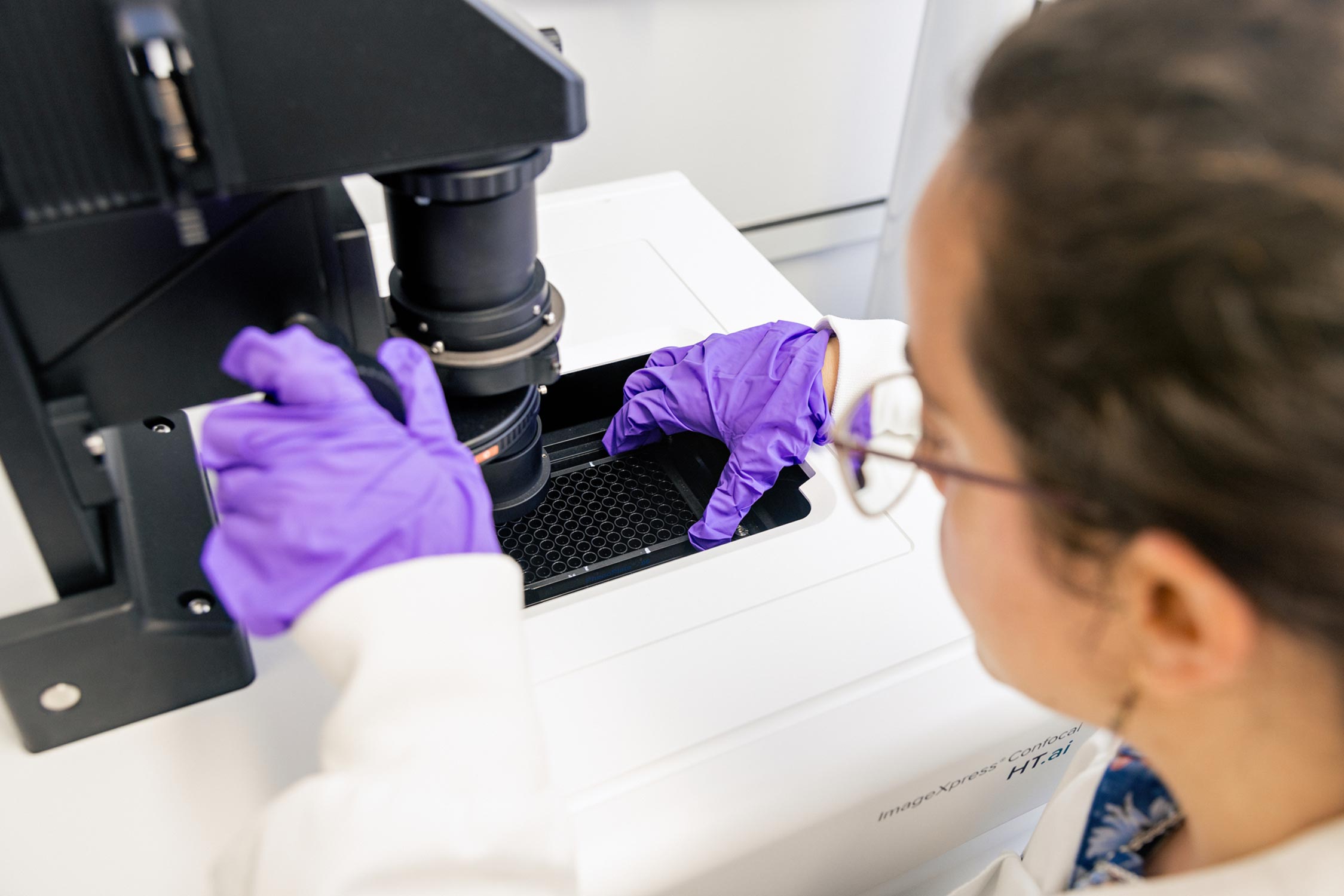 A technical specialist works with the high content imaging HT.ai instrument.