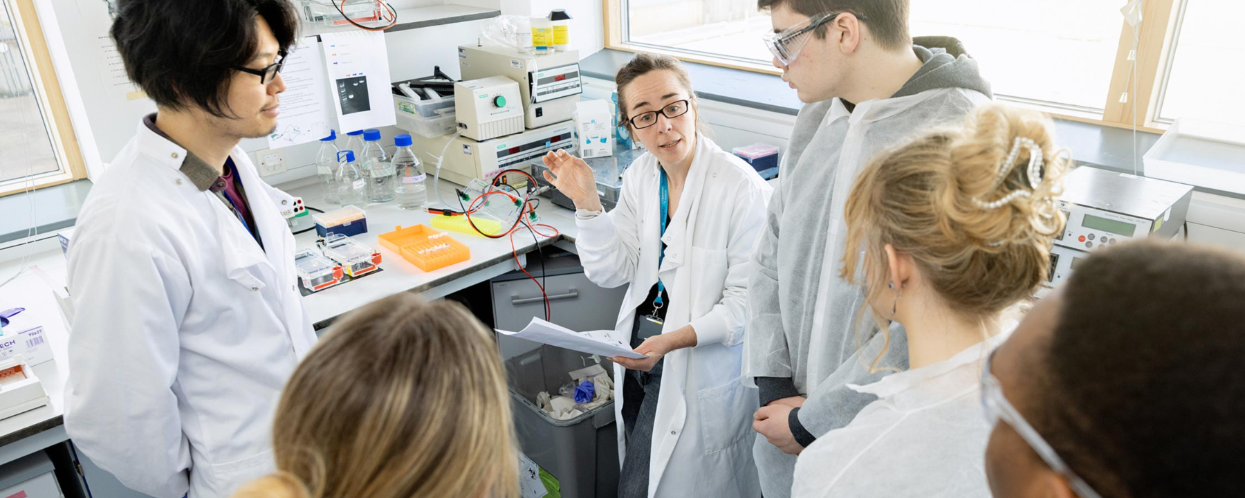 Two researchers and a group of 4 school students in discussion